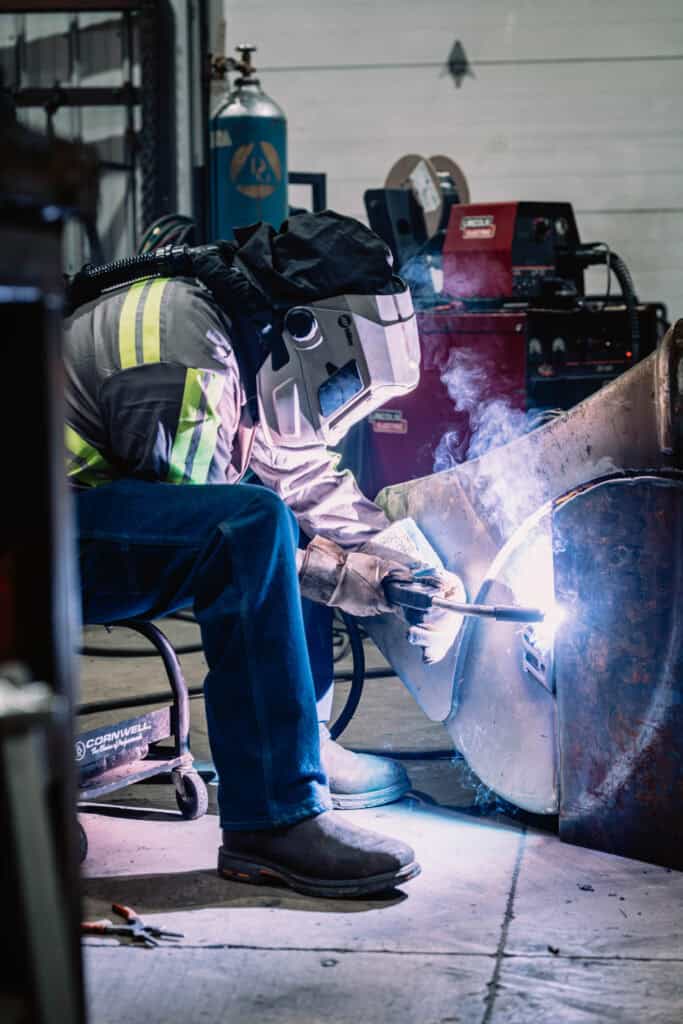 Skilled welder at Wesco Machine Works performing metal welding.