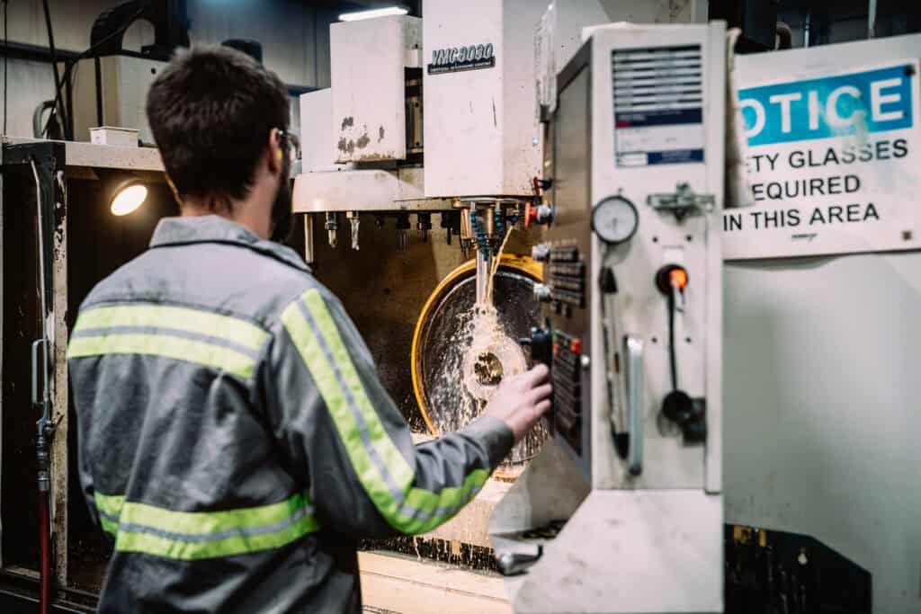 Industrial worker operating a CNC machine at Wesco Machine Works.
