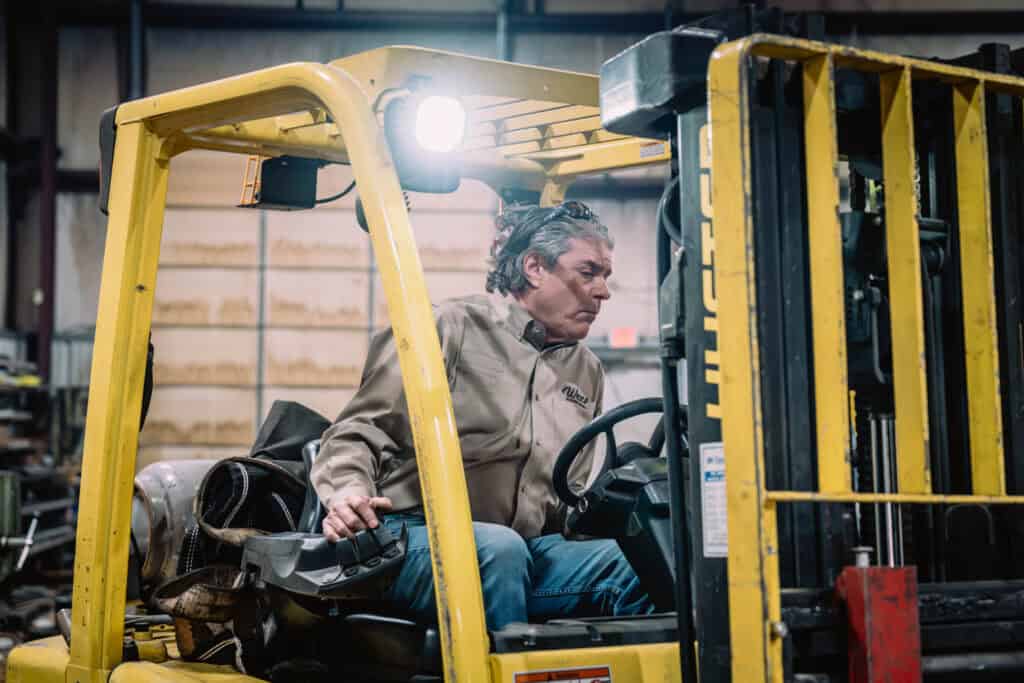 Forklift operator at Wesco Machine Works handling industrial equipment.