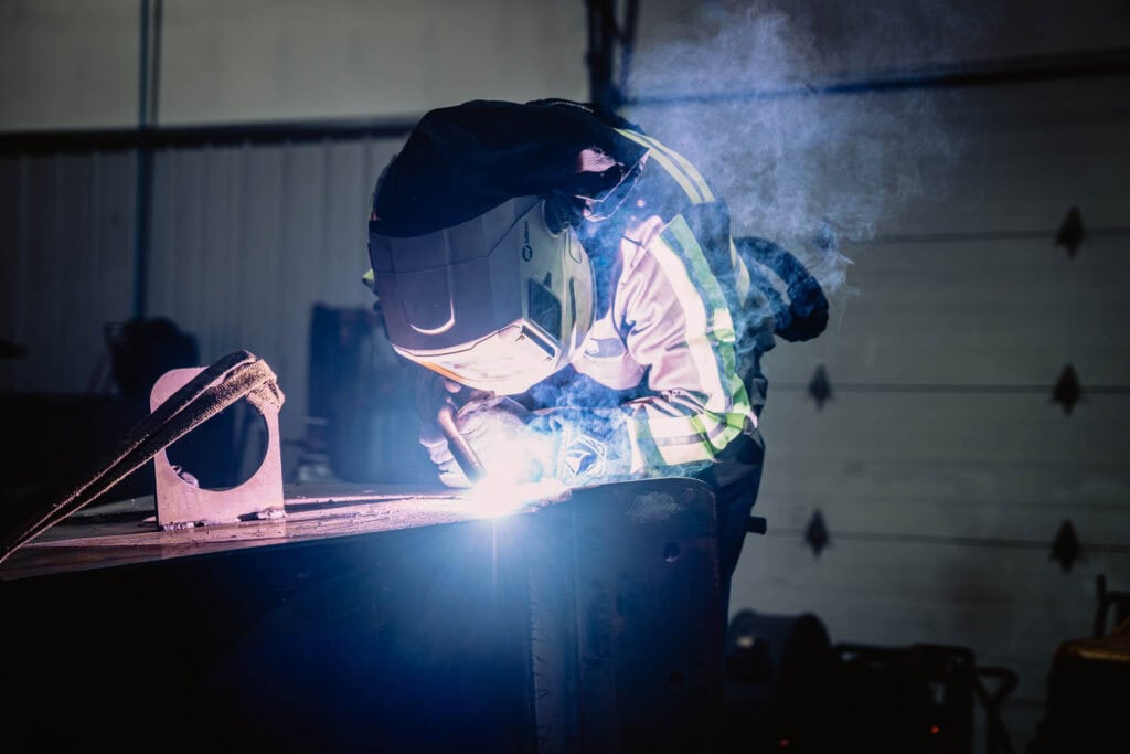 Welding process at Wesco Machine Works with skilled technician in safety gear.