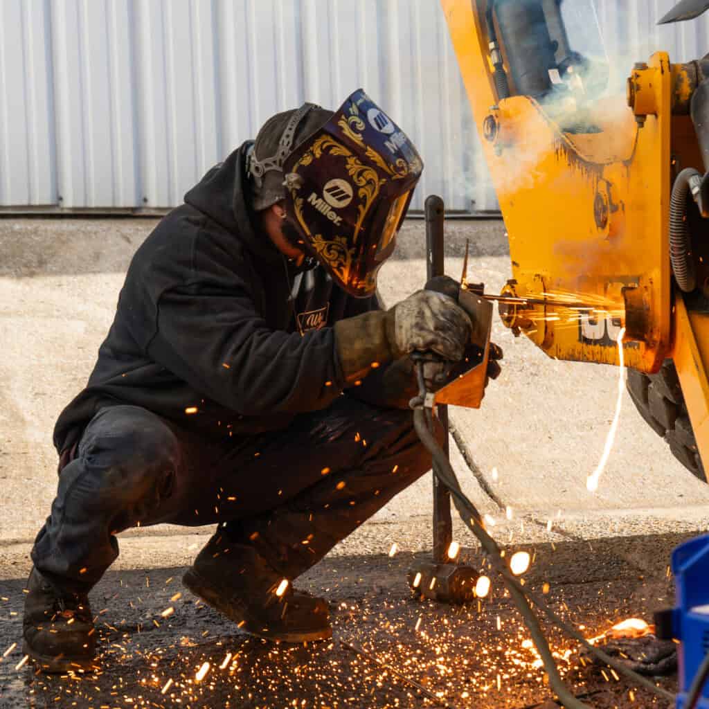 Welding worker at Wesco Machine Works using a cutting torch on metal.